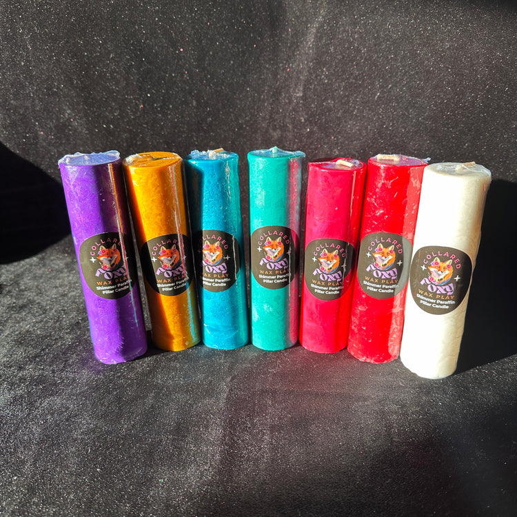 Row of shimmer and metallic paraffin wax play candles on black velvet, Collared Foxy