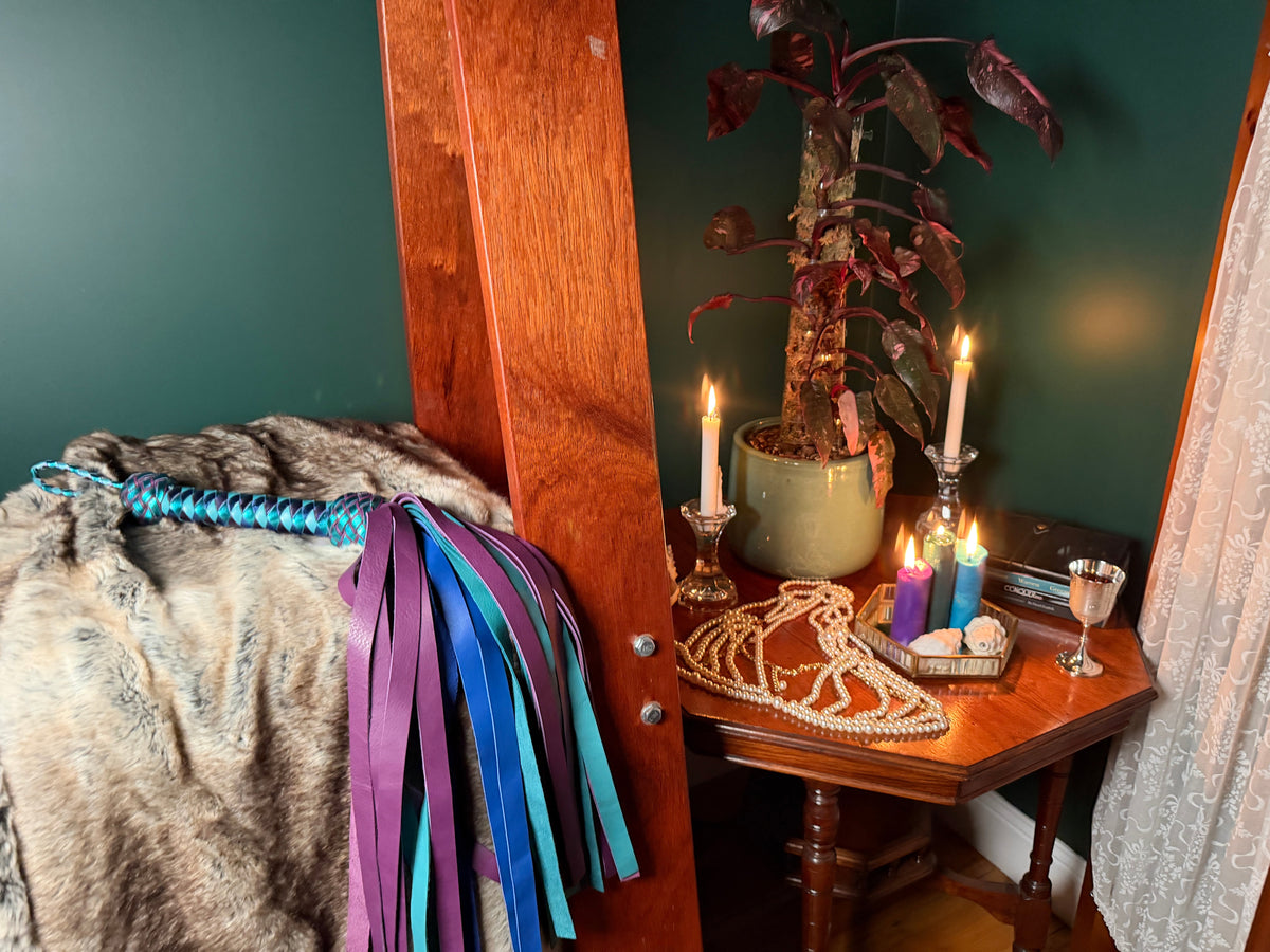 Handmade leather floggers on a timber A-frame against an emerald wall, Collared Foxy