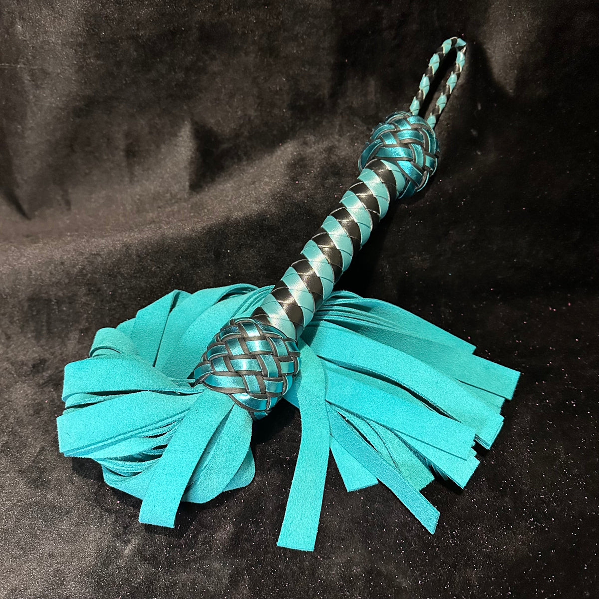 Teal cowhide suede flogger on black velvet, Collared Foxy