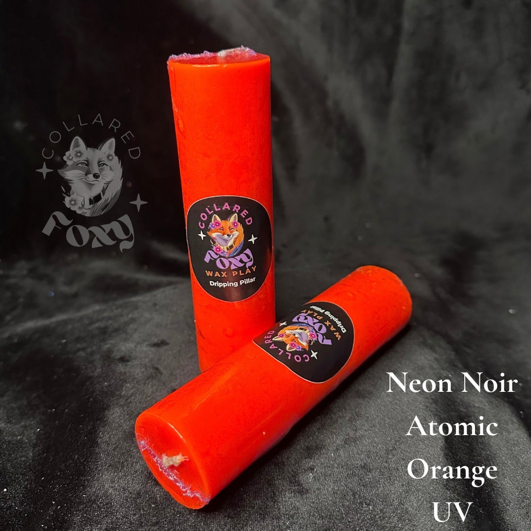 Atomic orange UV reactive paraffin dripping pillar candles on black velvet with Neon Noir label
