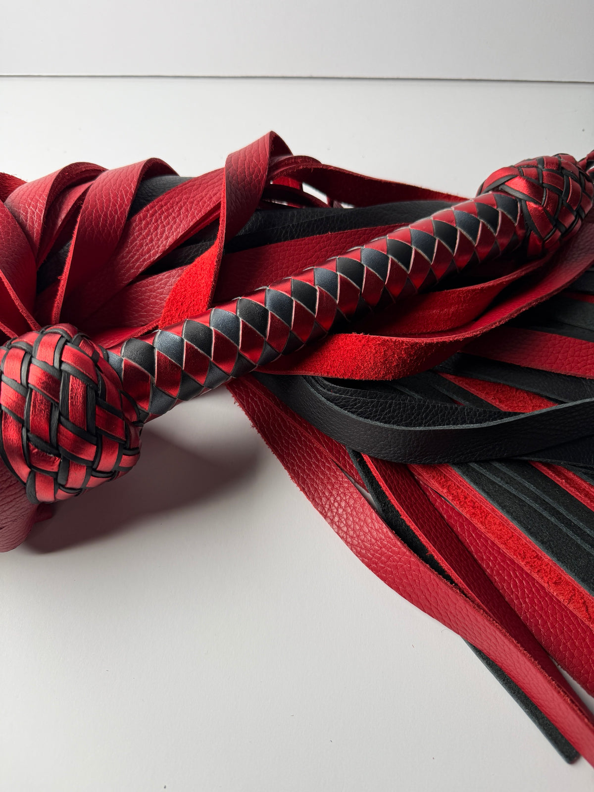 Garnet box braid handle in metallic red and black between two Turk's head knots