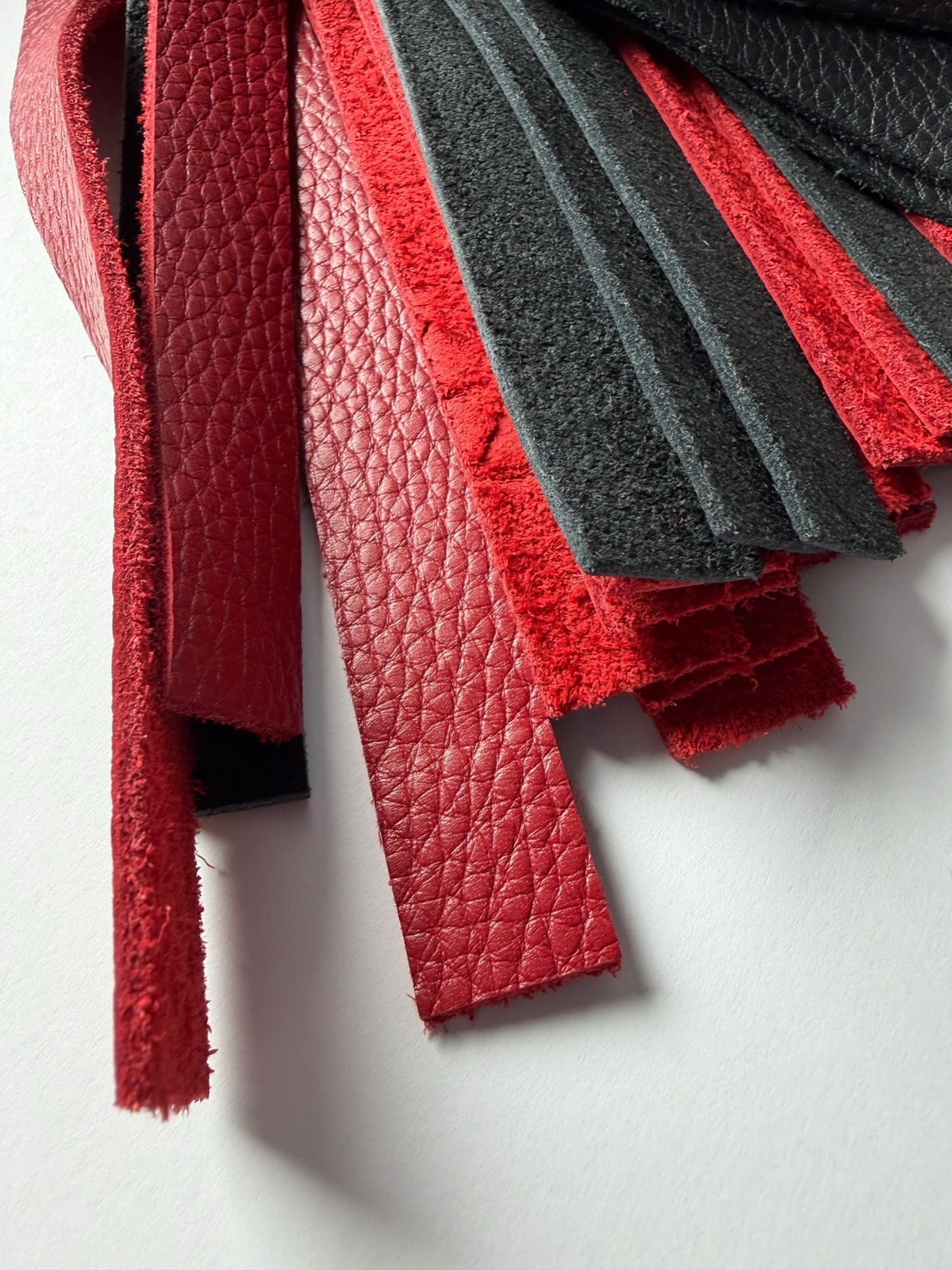 Garnet's red and black floater cowhide fall tips, showing grain and flesh side