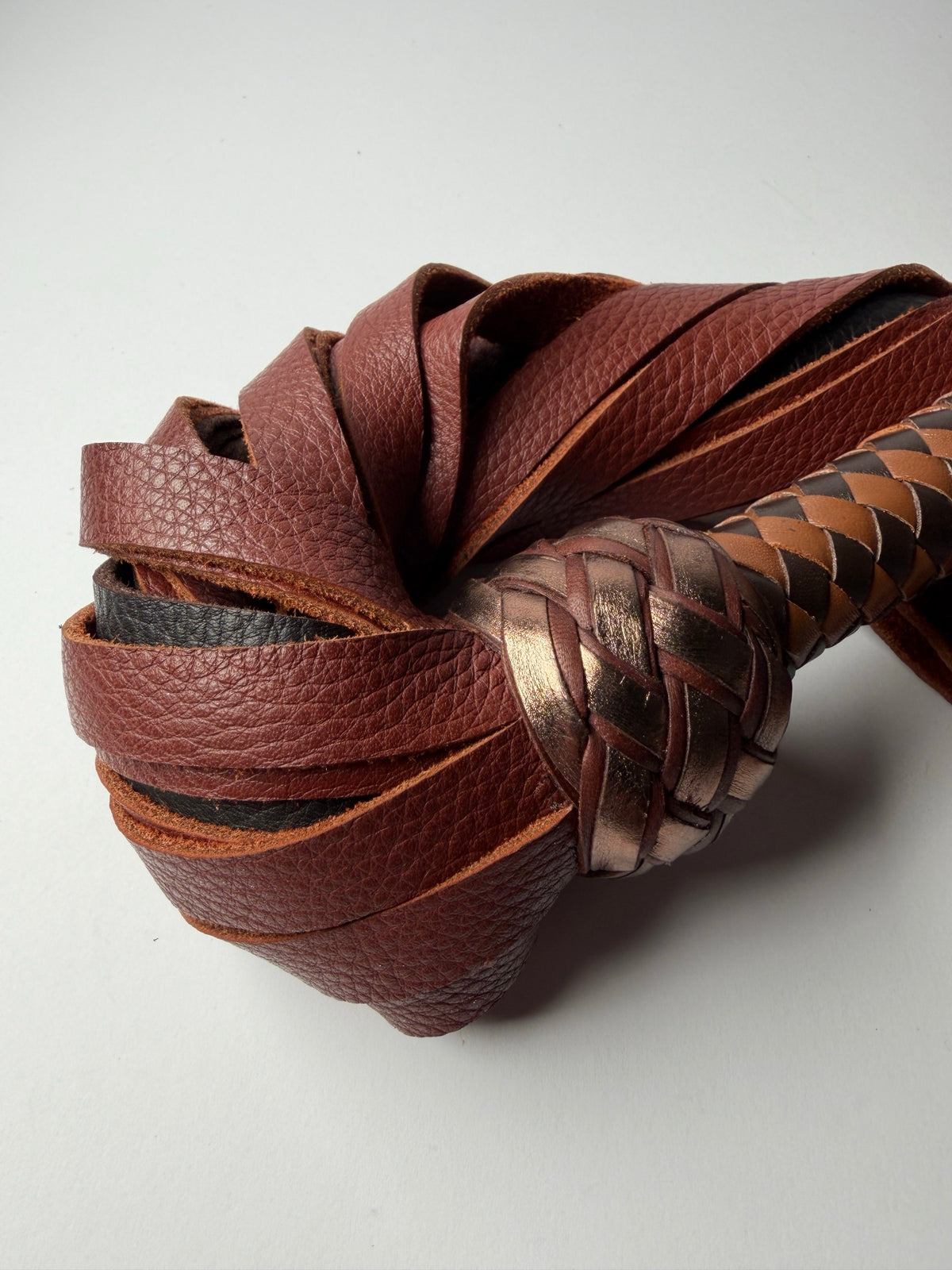 Close up of Oloroso's whisky floater cowhide falls curled around a metallic bronze Turk's head knot