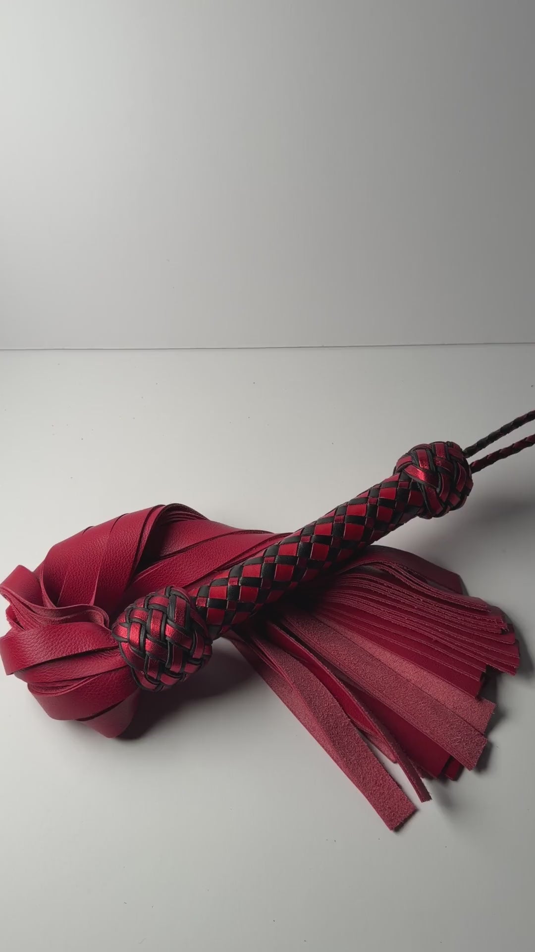 Video of the Vermilion flogger, red cowhide with a red and black diamond braid handle