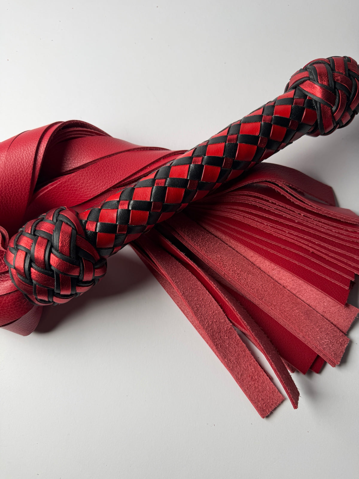 Vermilion diamond braid handle in red, metallic red and black between two Turk's head knots